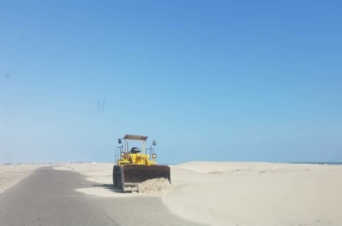 فرق الانتقالي تزيح الكثبان الرملية عن الطريق الدولي "عدن - أبين"