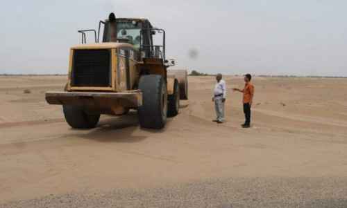 فرق فنية تواصل إزاحة الرمال من خط الحسيني في لحج